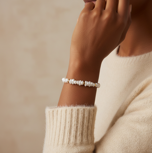 Person wearing a pearl bracelet with gold accents