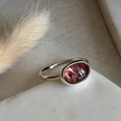 Silver ring with a pinkish-purple tourmaline stone on a light background