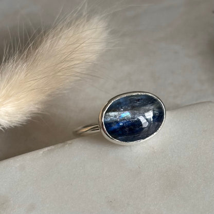 Silver ring with a blue kyanite stone on a light background