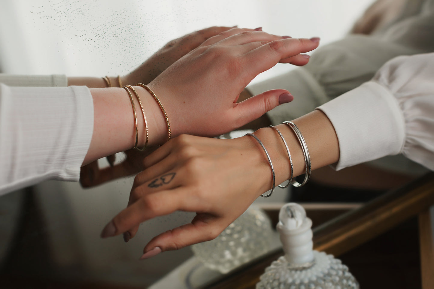 Close-up of two people's hands with bracelets on a blurred background