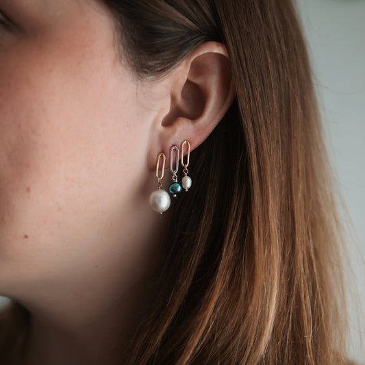 Close-up of a person wearing earrings with a blurred background