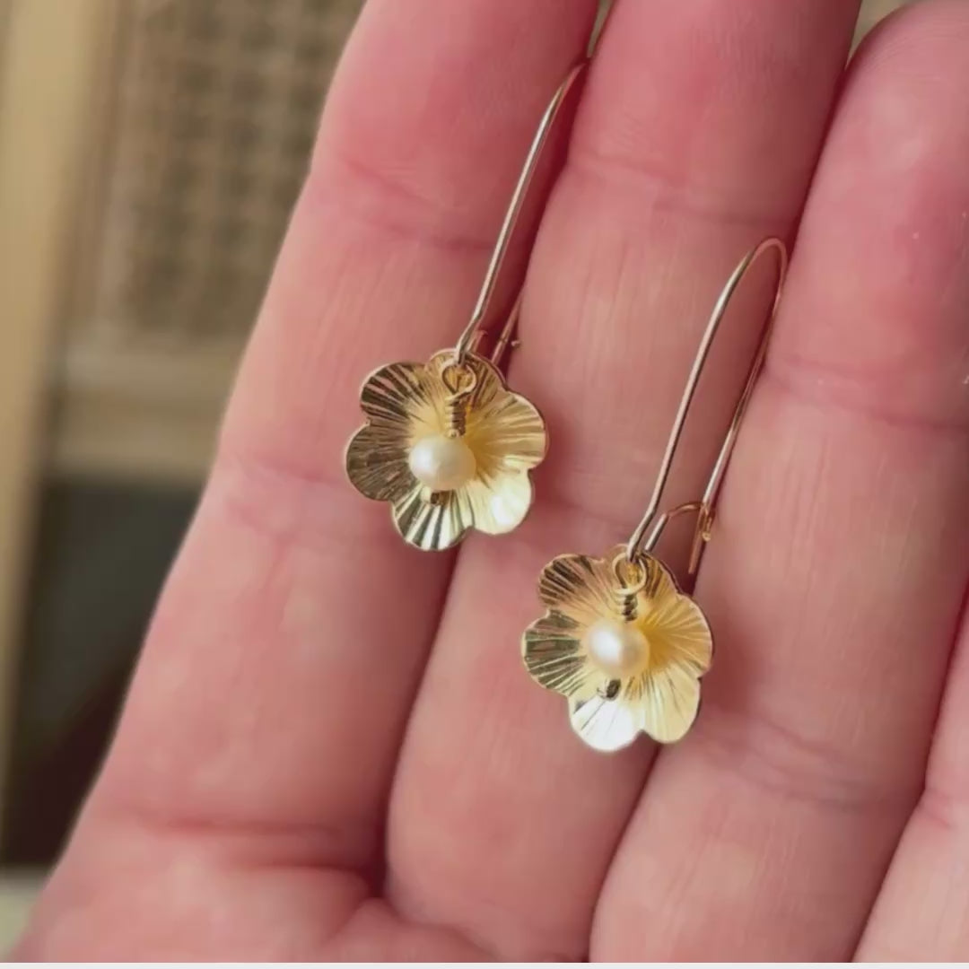 video showing gold flower earrings with a central pearl