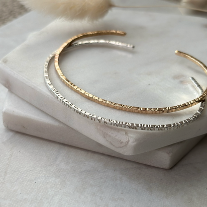 Gold and silver bangles on a marble surface