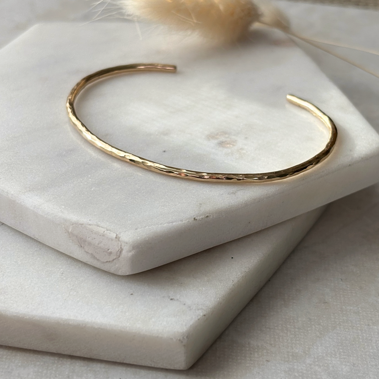 Gold bracelet on a white stone surface