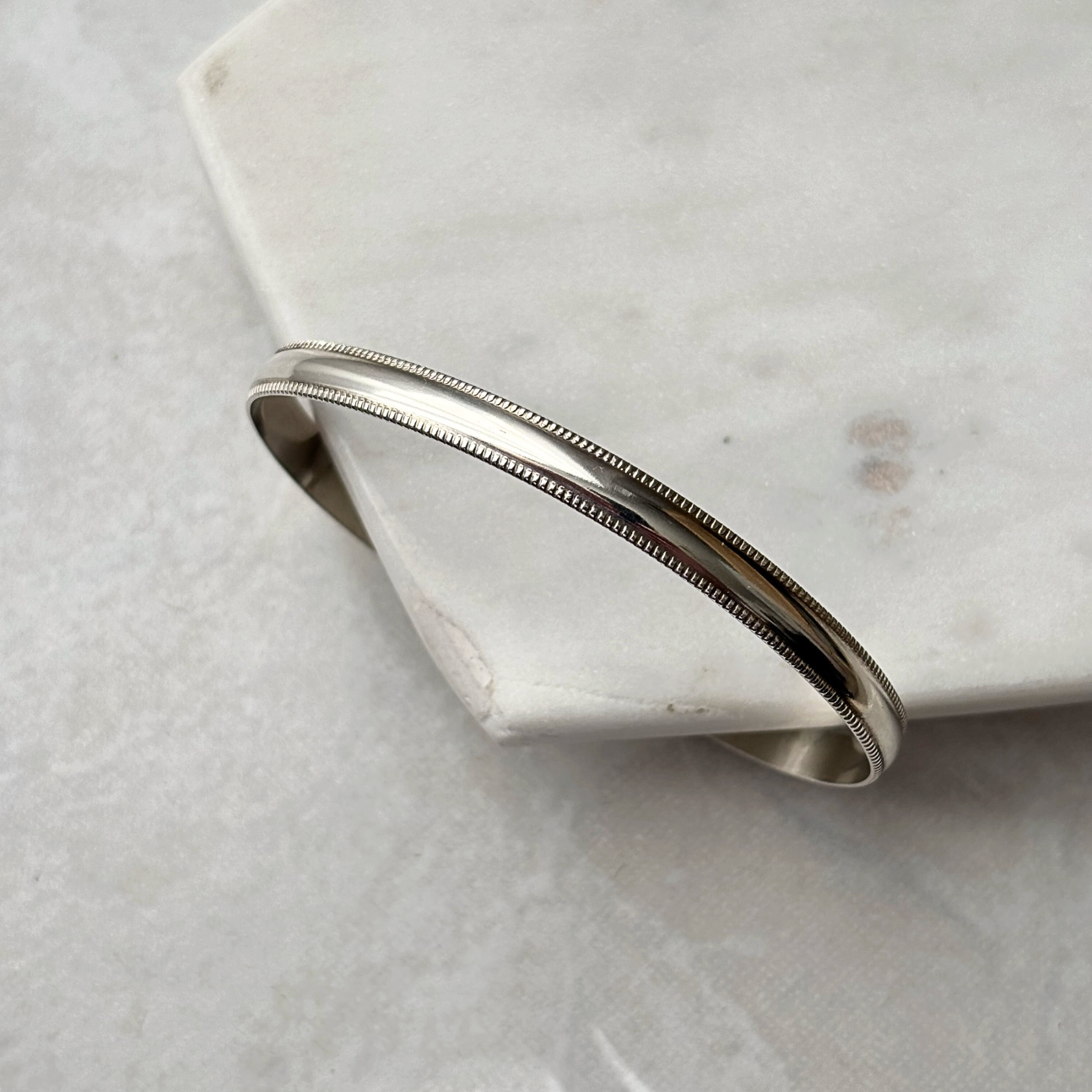 Silver bracelet on a marble surface