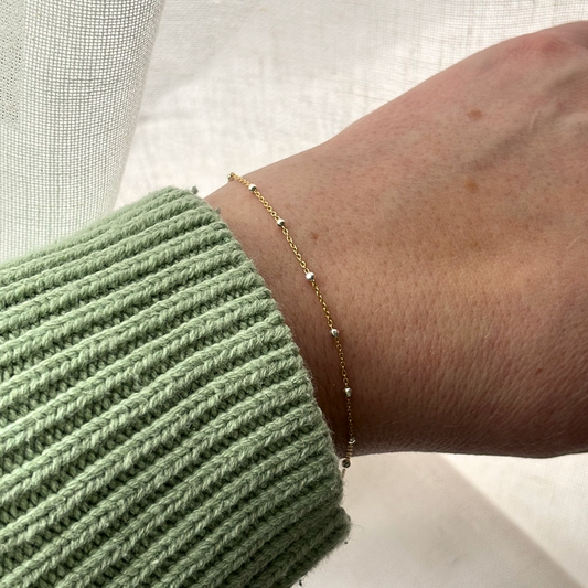 gold and silver chain bracelet on a wrist