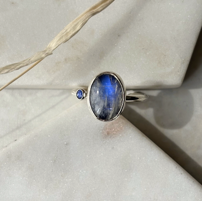 silver ring with a blue gemstone on a marble background