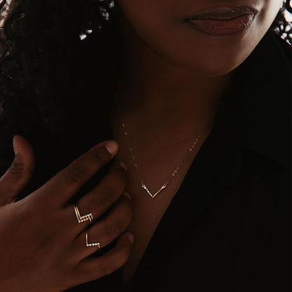A person wearing three rings, with a gold band and silver accents.