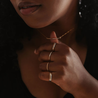 A person with brown skin wearing mixed metal rings.