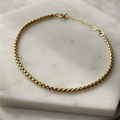 Gold chain bracelet on a marble surface